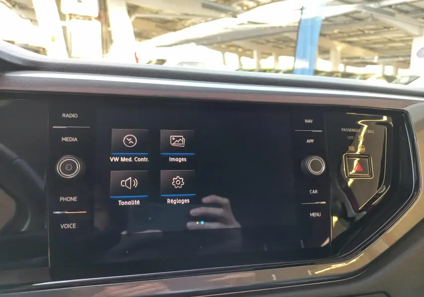 Écran tactile central du tableau de bord d'une Volkswagen Polo 2019 avec options multimédia et commandes visibles.