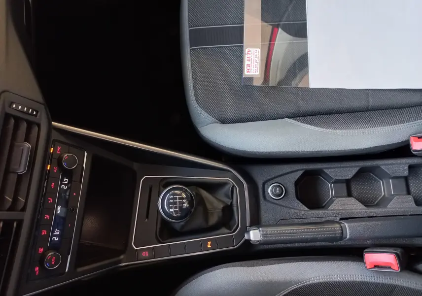 Gros plan sur la console centrale de la Volkswagen Polo Rouge Flash 2019 avec levier de vitesses manuel et commandes climatisation.