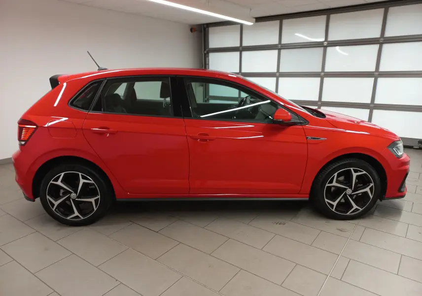 Profil droit d'une Volkswagen Polo 1.0 TSI 115 R-Line rouge Flash, avec jantes alliage et intérieur visible.