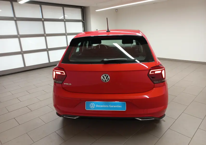 Vue arrière d'une Volkswagen Polo Rouge Flash 2019 avec feux LED et double sortie d'échappement intégrée en intérieur showroom.