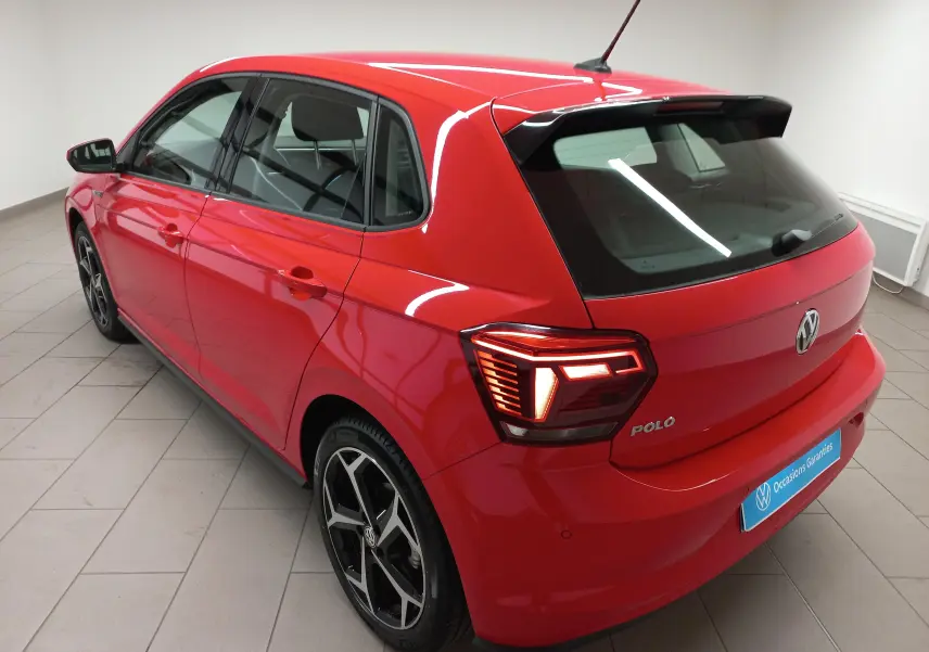Volkswagen Polo Rouge Flash 2019 vue 3/4 arrière droit avec feux allumés et jantes R-Line noires.