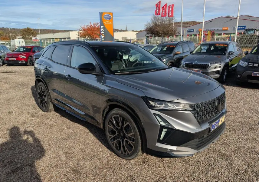 Renault Austral gris métallisé en 3/4 avant droit, avec jantes noires et toit noir étoilé visible en extérieur.