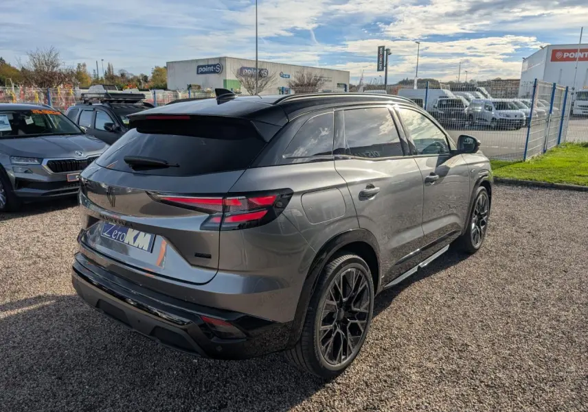 Vue 3/4 arrière droite d’un Renault Austral gris métallisé avec toit noir étoilé et jantes alliage noires.