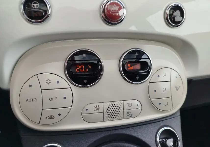 Vue rapprochée du tableau de bord blanc Bossa Nova avec commandes de climatisation digitale et boutons ronds sur Fiat 500 Lounge 2017.