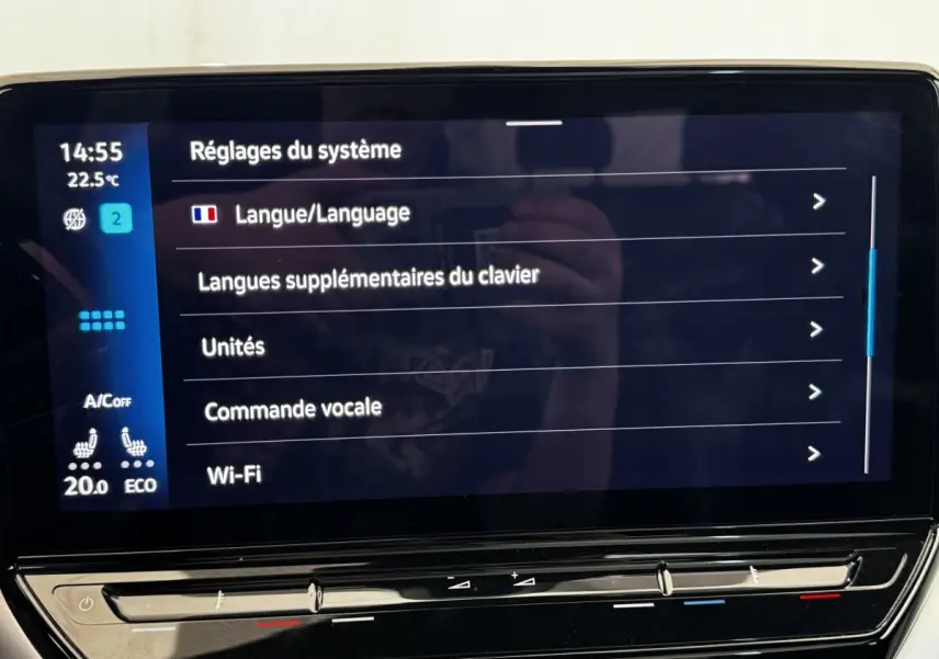 Écran tactile central du Volkswagen ID.4 blanc, affichant les réglages système en intérieur.