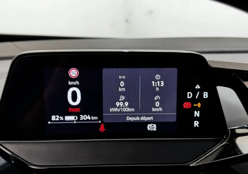 Affichage numérique du tableau de bord du Volkswagen ID.4 blanc, montrant la vitesse, autonomie et mode de conduite.