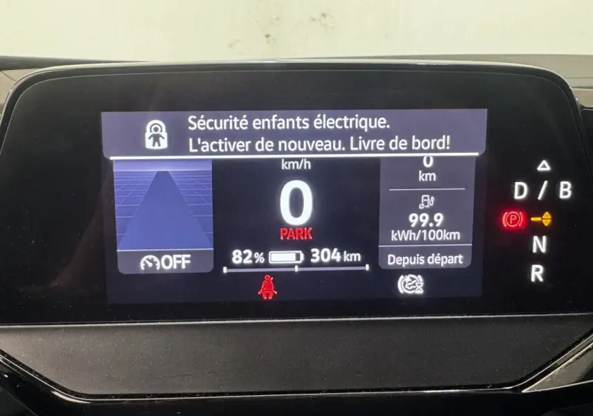 Affichage numérique du tableau de bord du Volkswagen ID.4 blanc, montrant vitesse, autonomie et alertes sécurité.