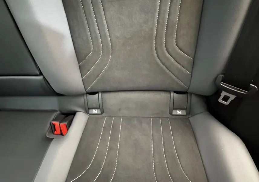 Gros plan sur la banquette arrière en tissu gris foncé avec coutures blanches et ceintures de sécurité rouges du Volkswagen ID.4.