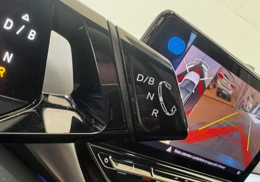 Gros plan intérieur sur le levier de vitesses et l'écran tactile affichant la caméra de recul du Volkswagen ID.4 blanc.