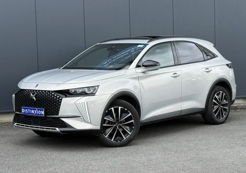 DS7 2025 Cristal Pearl en 3/4 avant droit, avec calandre noire distinctive et jantes alliage noires et argentées.