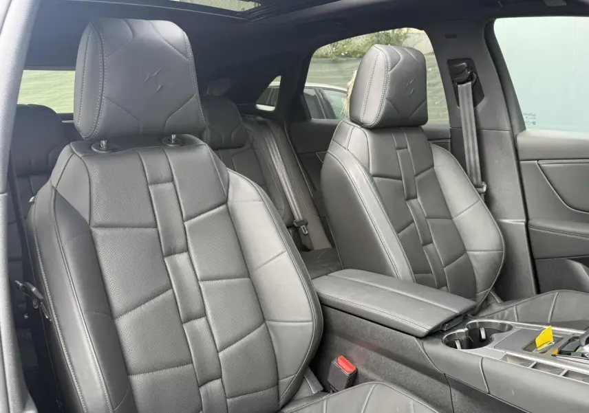Intérieur DS7 2025 en cuir noir Basalte, vue rapprochée des sièges avant avec toit ouvrant panoramique visible.