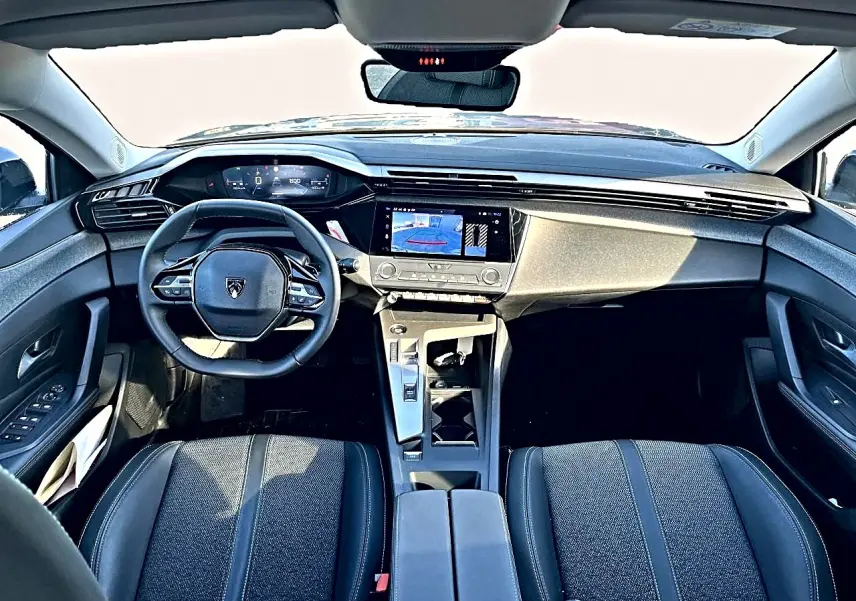Vue intérieure avant de la Peugeot 308 gris selenium, tableau de bord moderne avec écran tactile et volant multifonction.