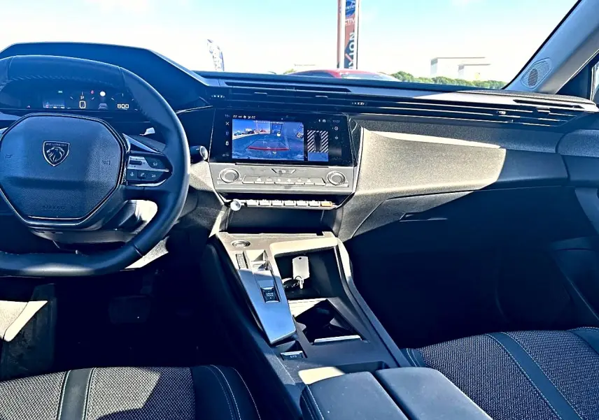 Vue intérieure avant de la Peugeot 308 1.5 BlueHDi 130 allure, tableau de bord et écran tactile central visibles.