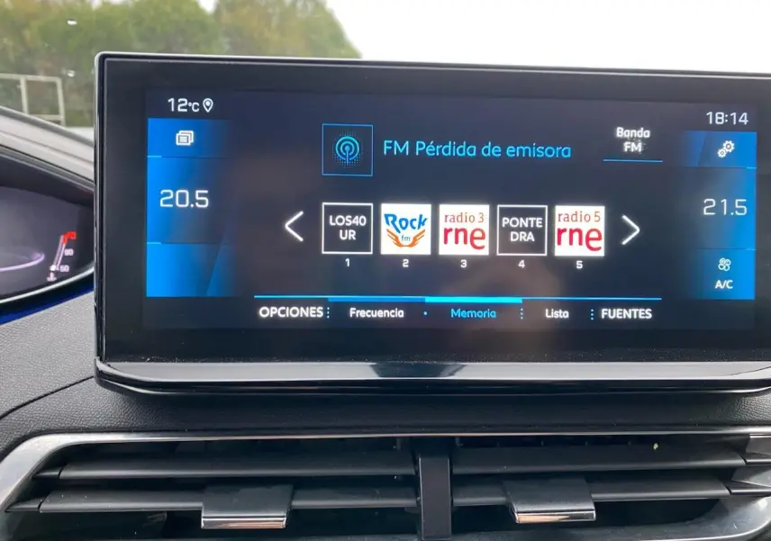 Écran tactile central du Peugeot 3008 gris platinium 2021 affichant les stations radio FM et la température intérieure.