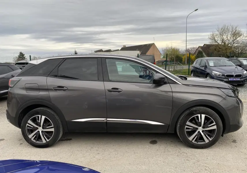 Profil côté gauche du Peugeot 3008 gris platinium 2021, soulignant ses lignes modernes et ses jantes alliage bicolores.