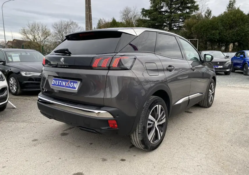 Vue 3/4 arrière droite d'un Peugeot 3008 gris platinium avec feux arrière à effet griffes et vitres teintées.