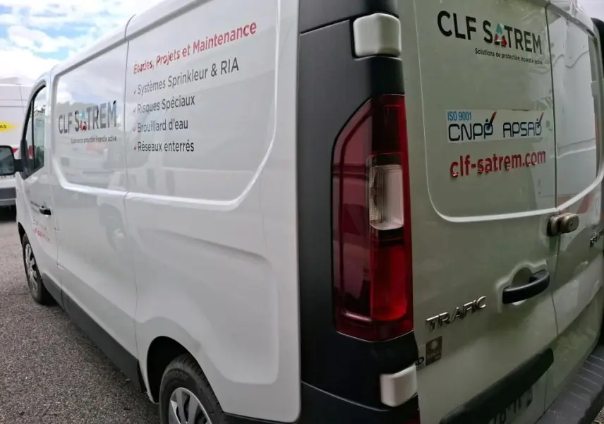 Vue arrière côté droit d'un Renault Trafic blanc avec marquages CLF SATREM et texte technique sur la carrosserie.