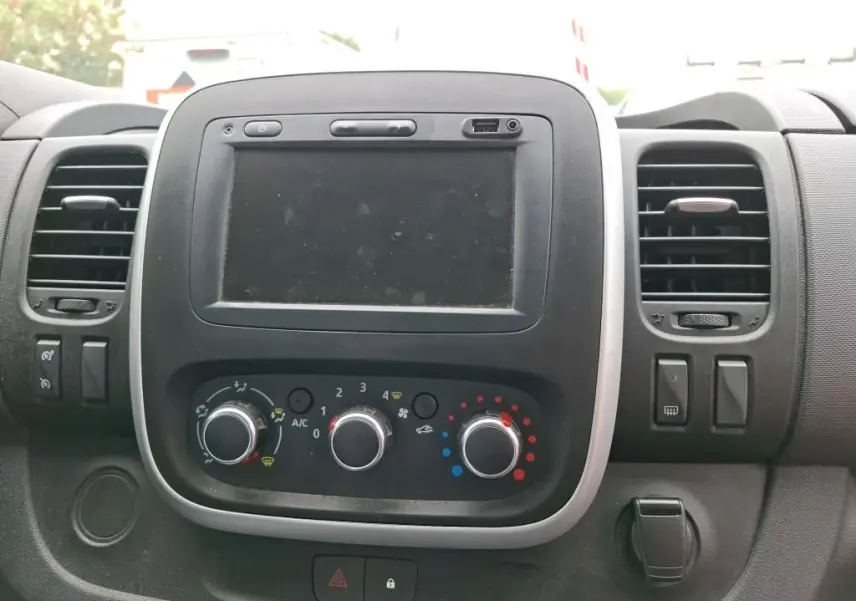 Tableau de bord du Renault Trafic Fourgon blanc 2021, vue frontale centrée sur l'écran tactile et les commandes de climatisation.