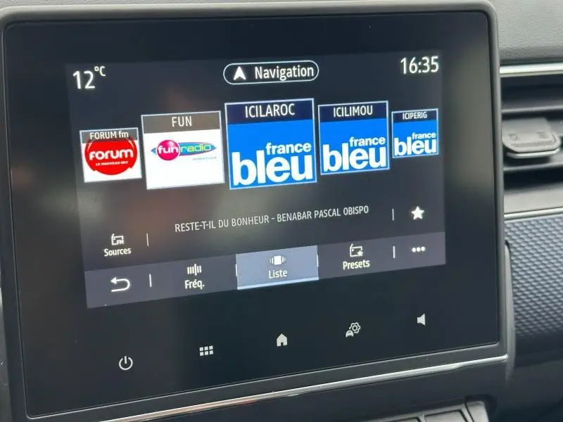 Écran tactile central du Renault Arkana 2025 affichant les stations radio, dans l'habitacle côté droit.