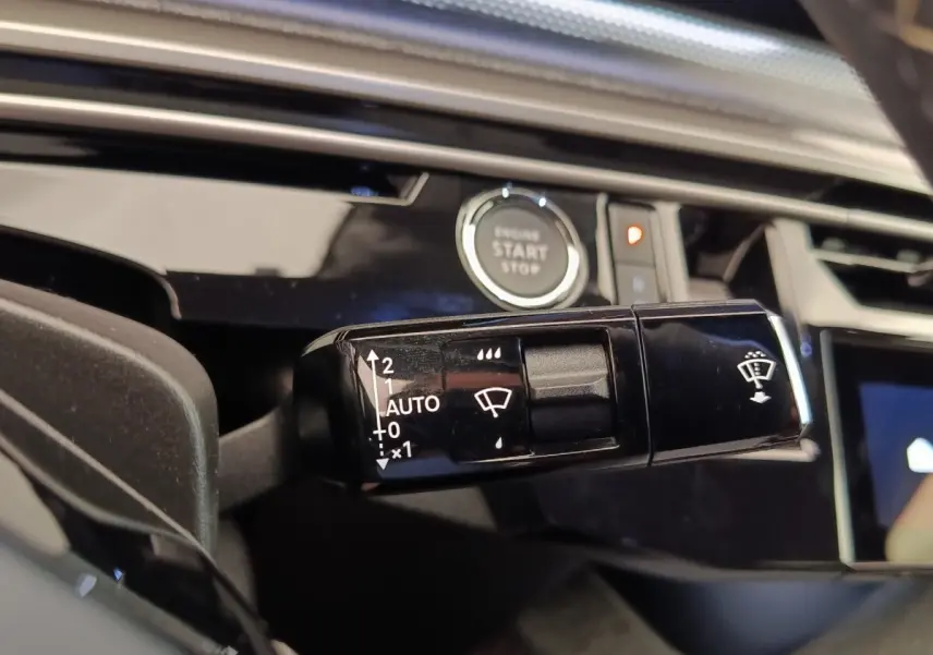 Gros plan sur la commande d’essuie-glace noire dans l’habitacle du Peugeot 3008 bleu, avec bouton démarrage visible.