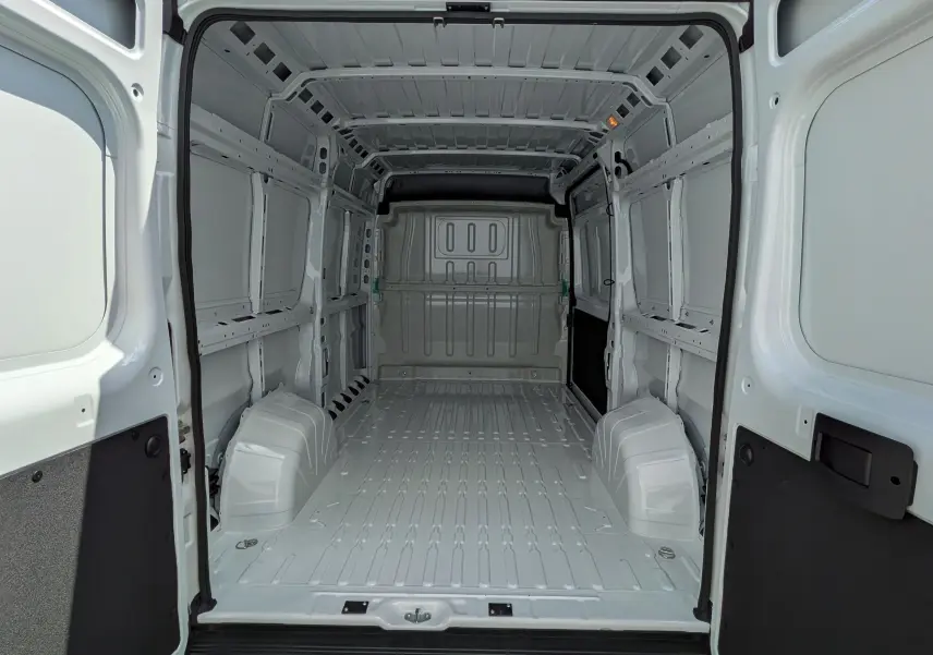 Vue intérieure arrière du fourgon blanc FIAT Ducato 2026, espace de chargement vide et métallique, sans aménagement.