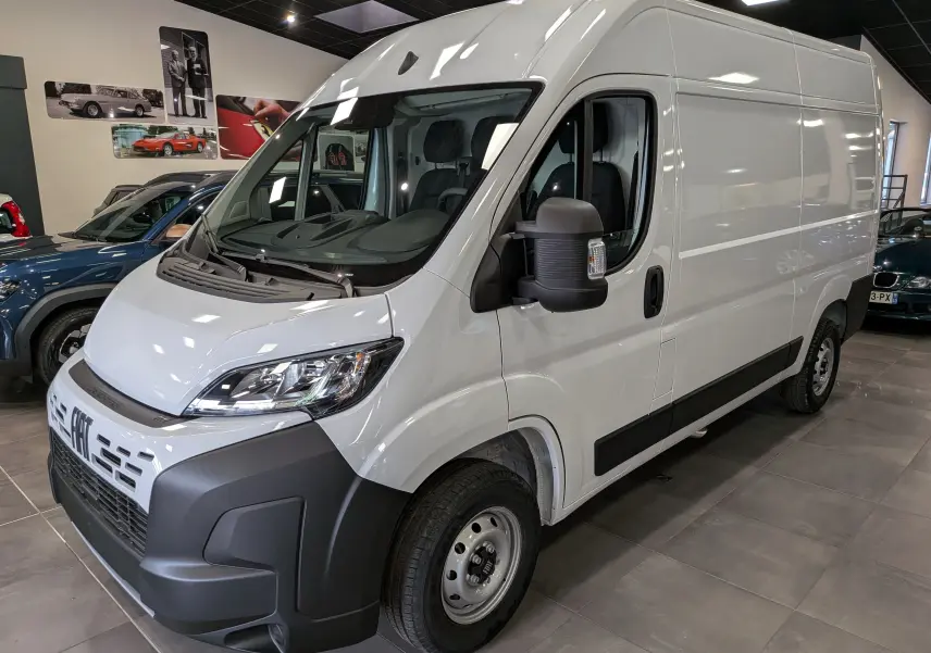Vue 3/4 avant droite d’un fourgon blanc Fiat Ducato M H2 3.3T avec pare-chocs noir et rétroviseur élargi.