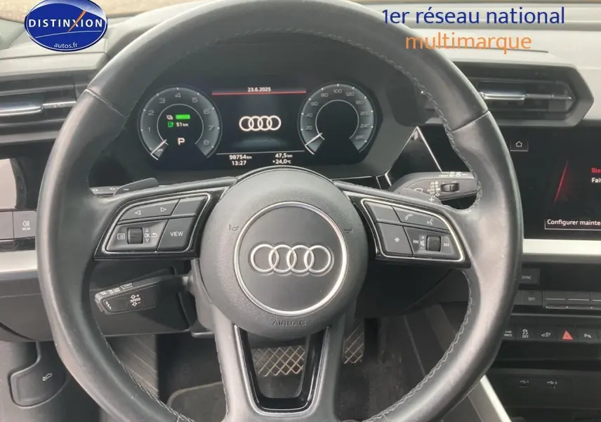 Vue rapprochée du volant cuir multifonction et du tableau de bord numérique d'une Audi A3 Sportback noire 2021.