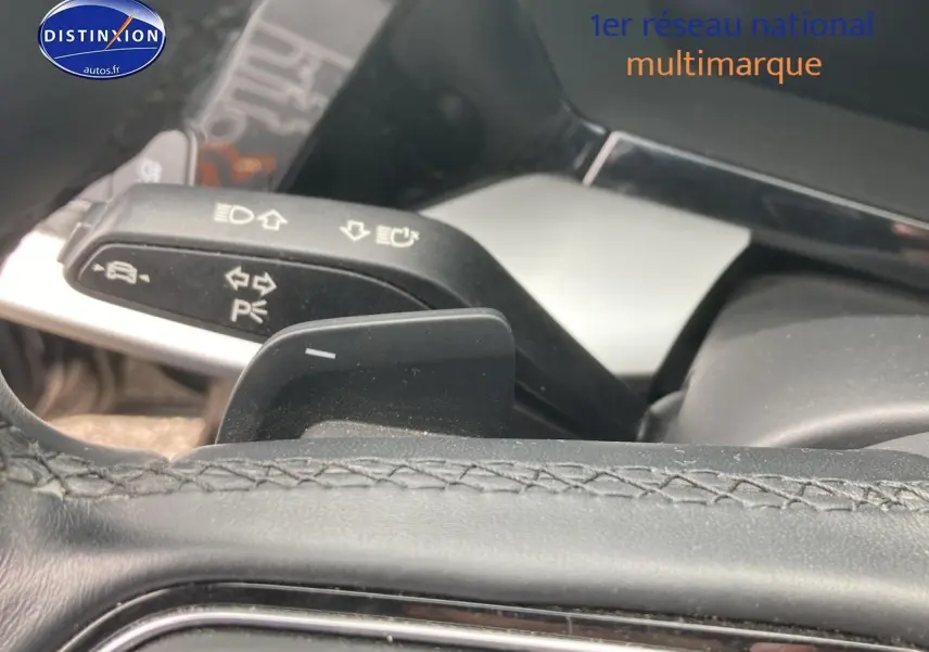 Gros plan sur la palette de changement de vitesses et la commande de clignotants dans l'habitacle d'une Audi A3 Sportback noire.