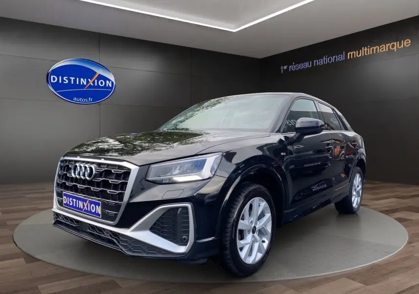 Audi Q2 noir mito en 3/4 avant droit, avec calandre S-Line et jantes alliage 17 pouces visibles en showroom