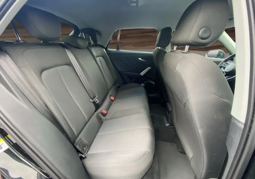 Vue intérieure arrière côté droit des sièges en tissu noir du SUV Audi Q2 noir Mito 2023.