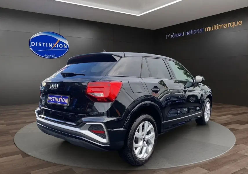 Audi Q2 noir mito vue 3/4 arrière droit, jantes alliage 17 pouces et hayon motorisé visible en showroom