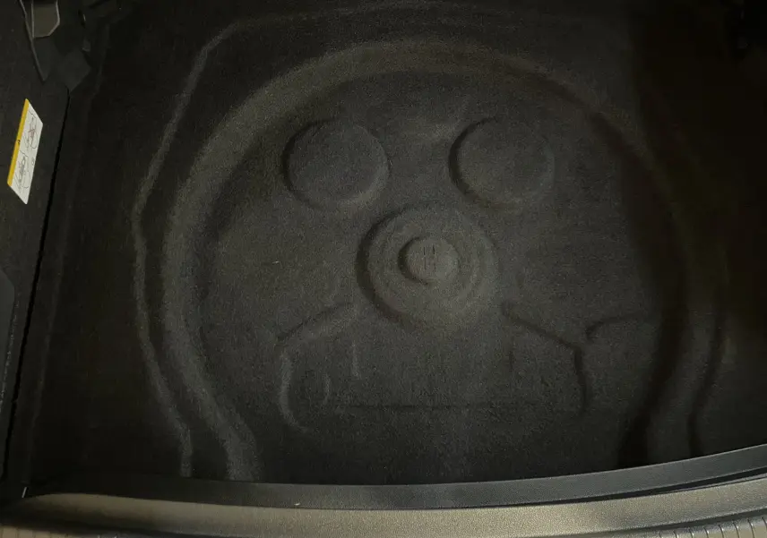 Coffre vide avec emplacement de roue de secours du Volkswagen Tiguan 2024 en Nightshade Blue, vue intérieure arrière.