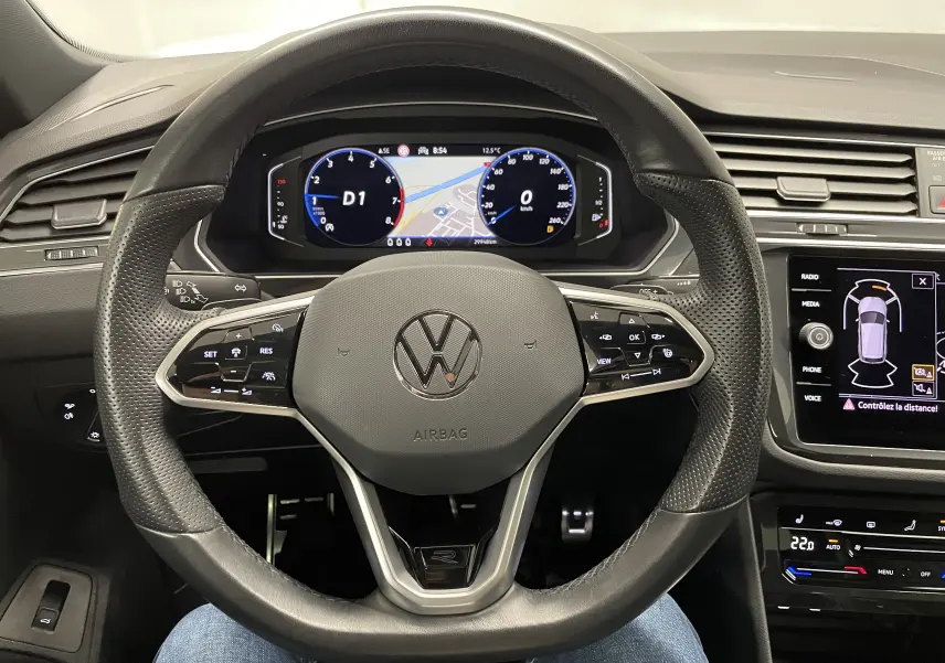 Vue centrée du volant multifonction noir du Volkswagen Tiguan 2024 avec tableau de bord numérique et écran tactile.