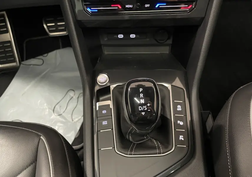 Vue rapprochée de la console centrale avec levier de vitesse automatique du Volkswagen Tiguan 2024 en intérieur noir.