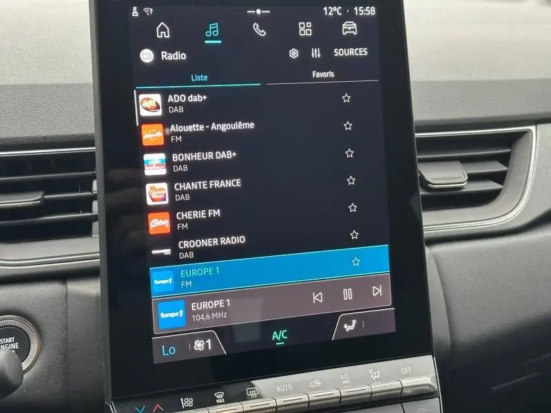 Gros plan sur l’écran tactile central du Renault Captur noir 2025 affichant les stations radio FM et DAB.