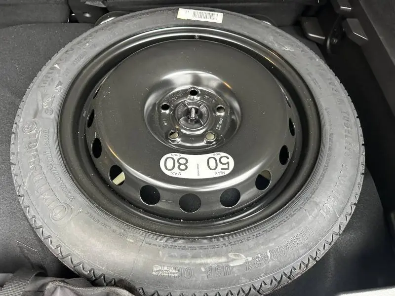 Gros plan sur la roue de secours noire du Renault Captur 2025, avec étiquette de limitation de vitesse visible.