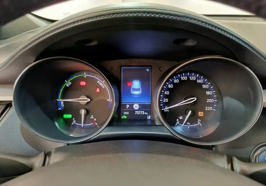 Vue rapprochée du tableau de bord du Toyota C-HR hybride 2022, affichage numérique et compteurs analogiques.