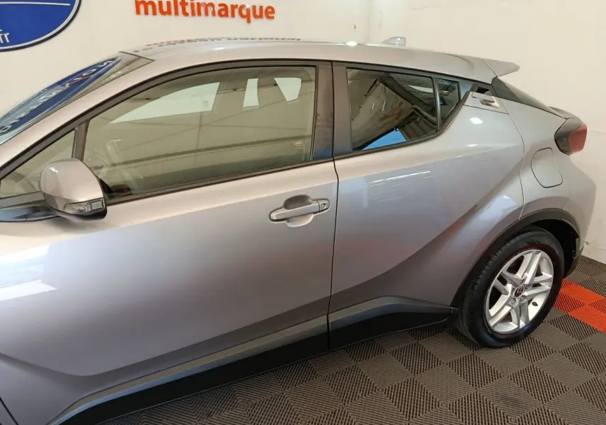 Vue latérale droite d'un Toyota C-HR gris clair 2022, mettant en valeur ses lignes anguleuses et la jante alliage.
