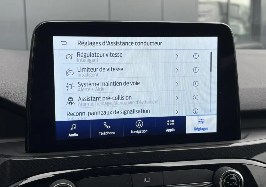 Écran tactile central du Ford Kuga 2023 affichant les réglages d’assistance conducteur en intérieur noir.