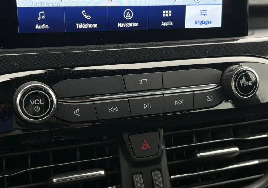 Détail de la console centrale du Ford Kuga 2023 avec commandes audio et écran tactile visible en partie.