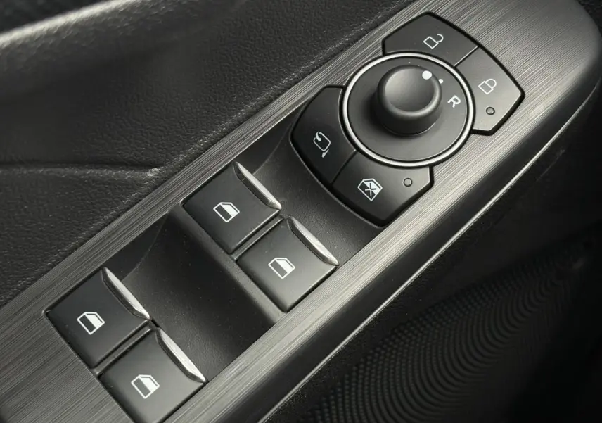 Gros plan sur les commandes de lève-vitres et rétroviseurs côté conducteur du Ford Kuga gris graphite 2023.