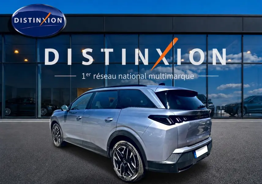 Peugeot 5008 Hybrid 145 allure gris artense en 3/4 arrière droit, avec jantes alu et feux arrière LED distinctifs.