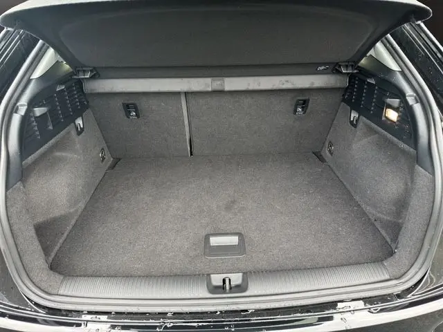 Coffre ouvert d'un Audi Q2 noir Mito 2023, montrant un espace de chargement propre et bien agencé.