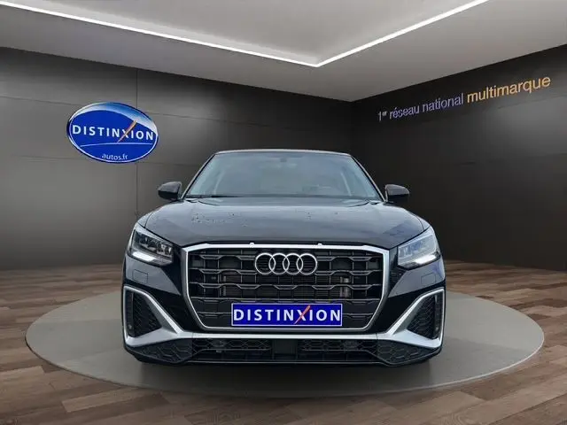 Vue frontale d'un Audi Q2 35 TFSI S-Line noir mito, avec calandre hexagonale et éclairage LED distinctif.