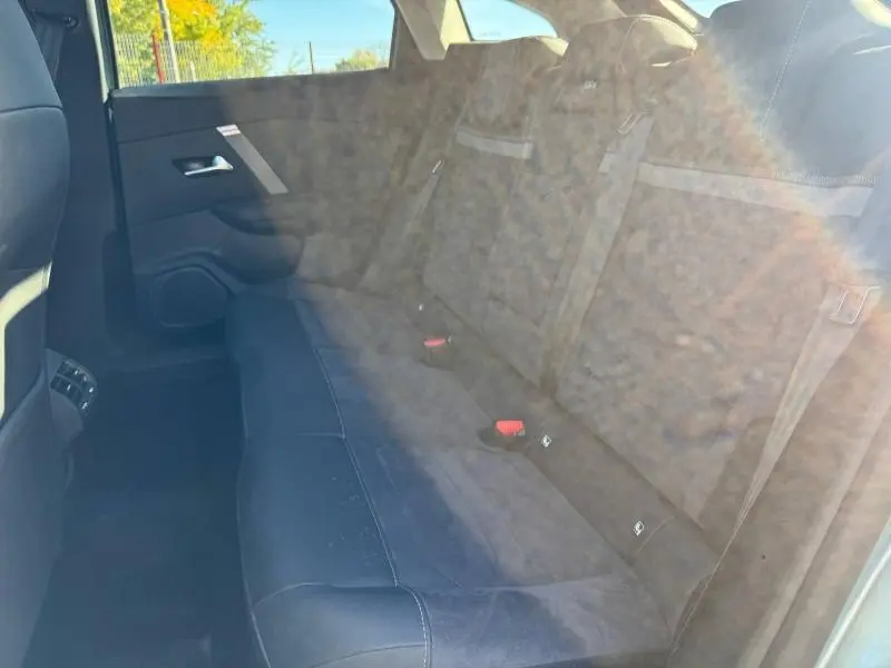 Vue intérieure côté droit des sièges arrière en tissu gris foncé du Citroën C4 2024, avec ceintures de sécurité visibles.