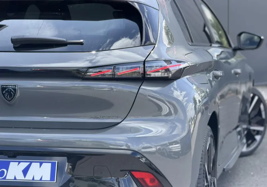 Vue 3/4 arrière droite d'une Peugeot 308 gris Selenium avec feux arrière LED en forme de griffes et jantes alliage bi-tons.