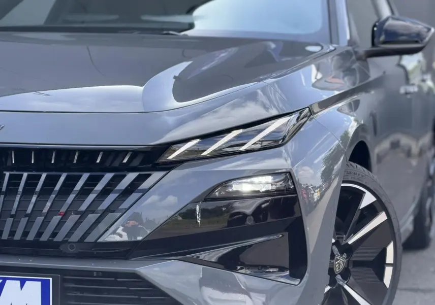 Gros plan 3/4 avant droit du Peugeot 308 NV Hybrid gris Selenium avec phares LED et jantes alliage bi-tons.