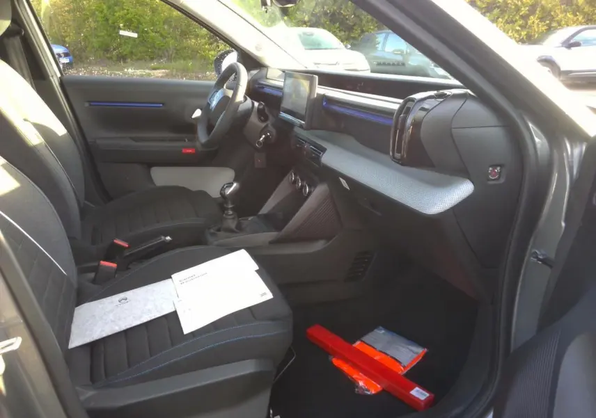 Vue intérieure côté passager avant d'une Citroën C3 gris foncé 2025, avec sièges noirs et détails bleu Ultra Blue.