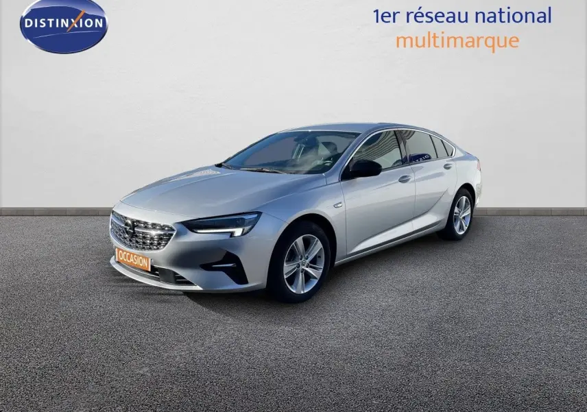 Opel Insignia gris minéral métal vue 3/4 avant droit sur fond neutre avec calandre chromée et phares LED.