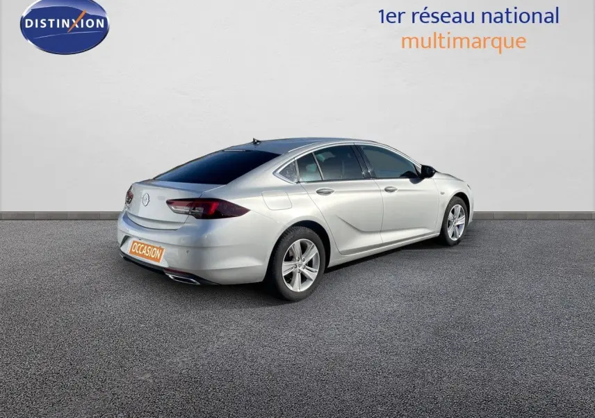 Opel Insignia gris minéral métal vue 3/4 arrière droit sur fond neutre avec vitres teintées et jantes alliage.